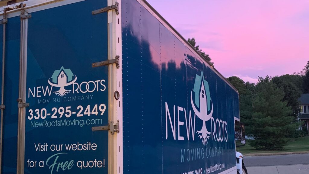 New Roots Moving Company truck at sunset.